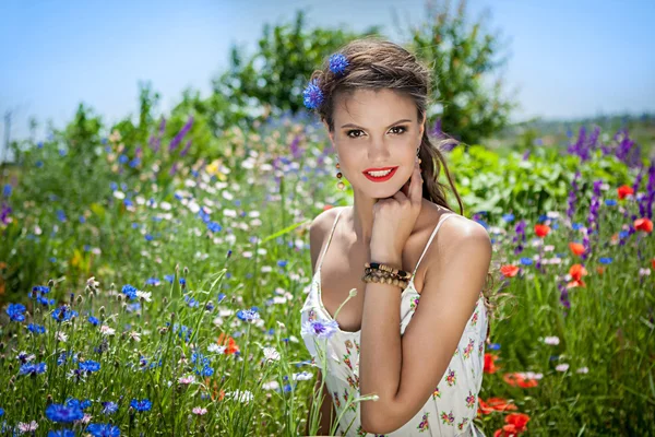 Schöne glückliche Weibchen in den Wildblumen — Stockfoto