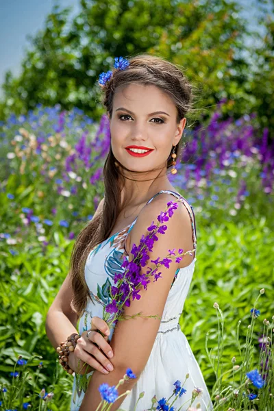 Schöne glückliche Weibchen in den Wildblumen — Stockfoto