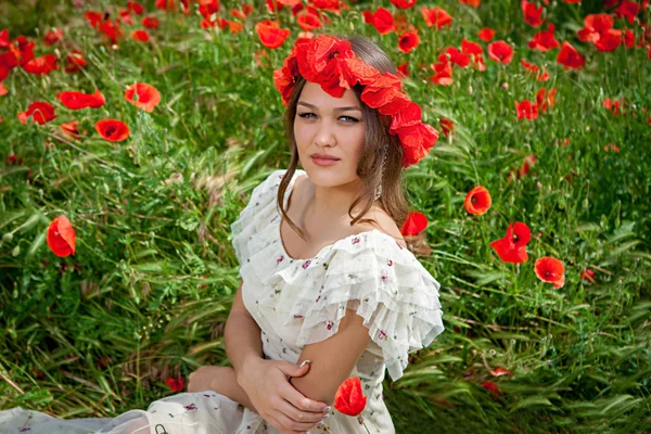 Krásná žena sedí v máku květiny — Stock fotografie