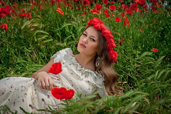 Beautiful  woman sitting in the poppy flower — Stock Photo, Image