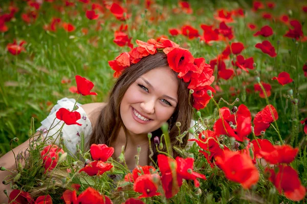 Haşhaş çiçeğinin üzerinde oturan güzel kadın — Stok fotoğraf