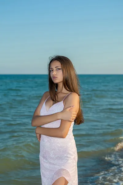 Giovane ragazza triste vicino al mare su un tramonto — Foto Stock