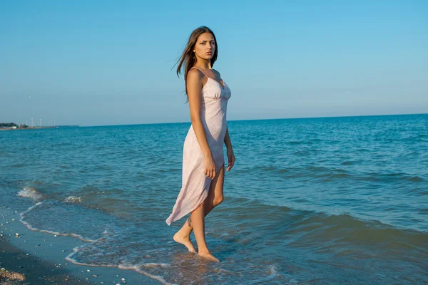 Giovane ragazza triste vicino al mare su un tramonto — Foto Stock