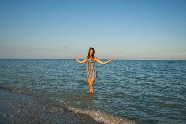 Young girl splashing the water in the sea — Stock Photo, Image