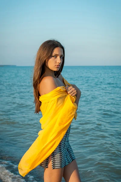 Young sad girl near the sea on a sunset — Stock Photo, Image