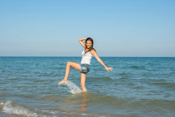 Młoda dziewczyna przelewanie wody w morzu — Zdjęcie stockowe