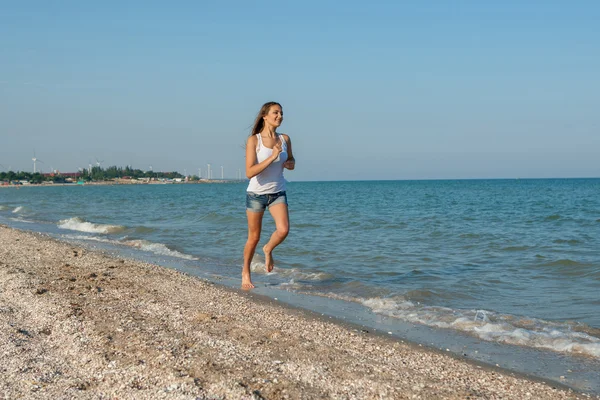 Young girl runs on the sea — Stock Photo, Image