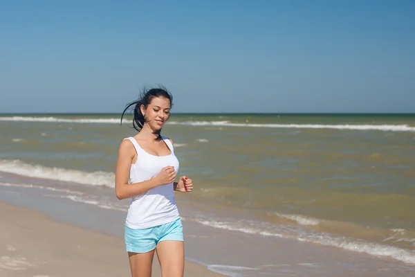 Молодая девушка бежит по морю — стоковое фото
