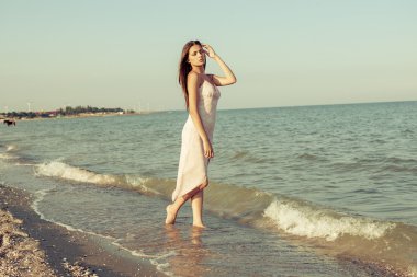 denize sıfır bir günbatımı üzerinde üzgün kız