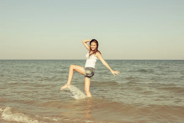 Young girl splashing the water in the sea — Stock Photo, Image