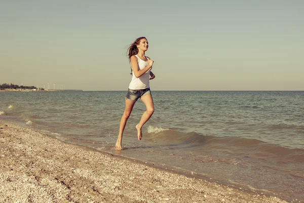 Young girl runs on the sea — Stock Photo, Image