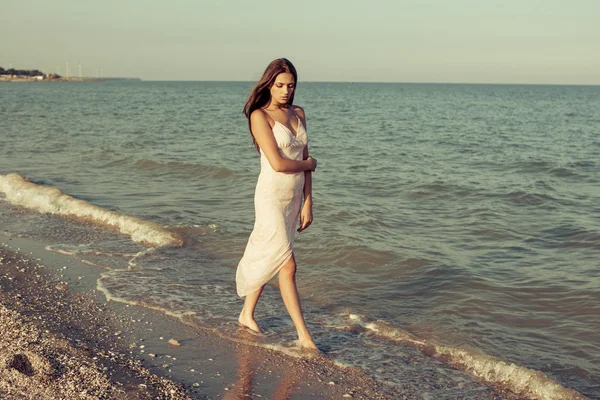 Giovane ragazza triste vicino al mare su un tramonto — Foto Stock