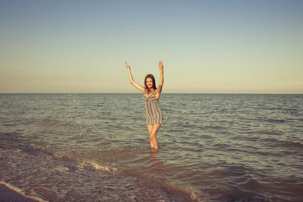 Young girl splashing the water in the sea — Stock Photo, Image