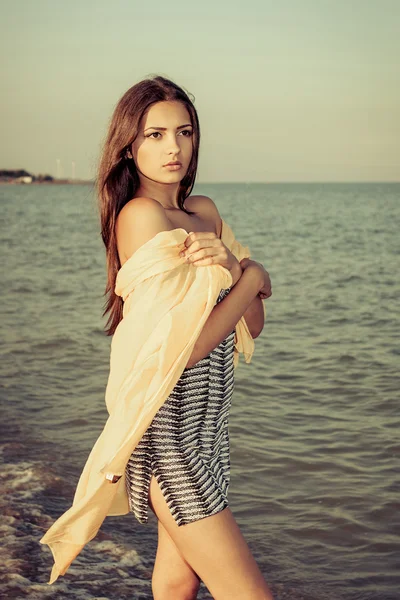 Young sad girl near the sea on a sunset — Stock Photo, Image