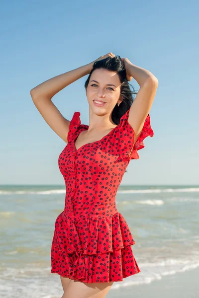 Giovane ragazza in abito rosso sul mare — Foto Stock