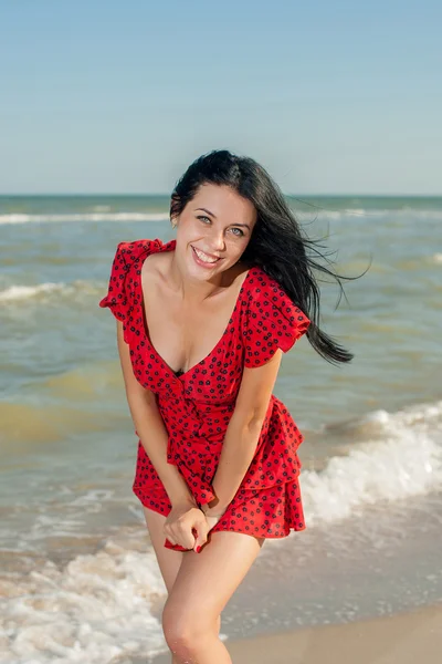 Jeune fille en robe rouge sur la mer — Photo