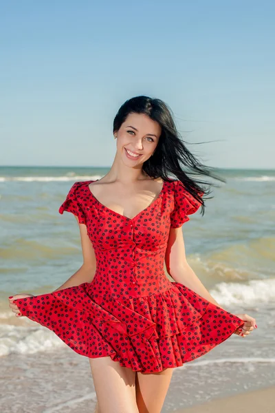 Jeune fille en robe rouge sur la mer — Photo