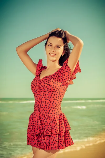 Молодая девушка в красном платье на море — стоковое фото