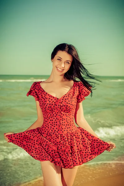 Young girl in red dress on the sea — Stock Photo, Image