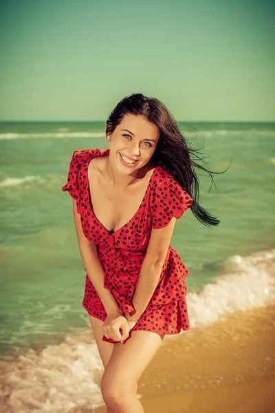 Denizin üzerinde Kırmızı elbiseli genç kız — Stok fotoğraf
