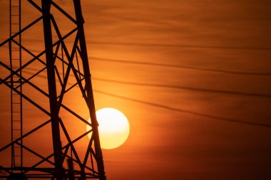 Yüksek voltajlı elektrik direğinin silüeti.