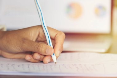 Close up shot human hand writing on the paper 