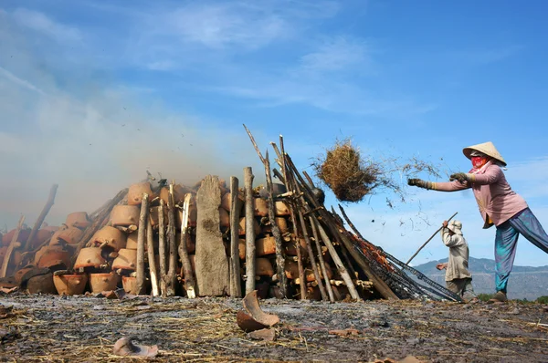 Vrouw gooien rijst traw te maken om te branden aardewerk oplaaien. Phan rang, viet nam-3 februari — Stockfoto