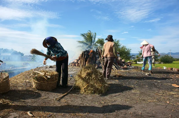 Woman pick up hearth for cooking out of burn area. PHAN RANG, VIET NAM- FEBRUARY 3 — Zdjęcie stockowe