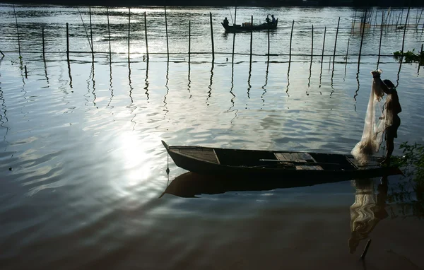 Pescador em pé no barco, pegar a rede — Fotografia de Stock