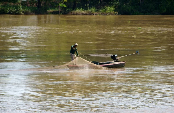 Group of fisherman catching fish by net on river