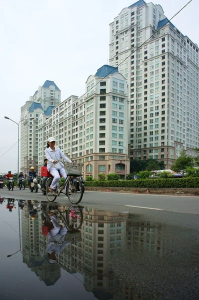People ride bicycle with high-rise building background — Stock Photo, Image