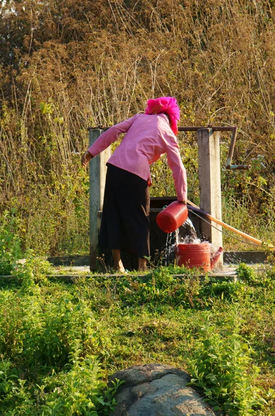 Mensen scoop goed water uit water — Stockfoto