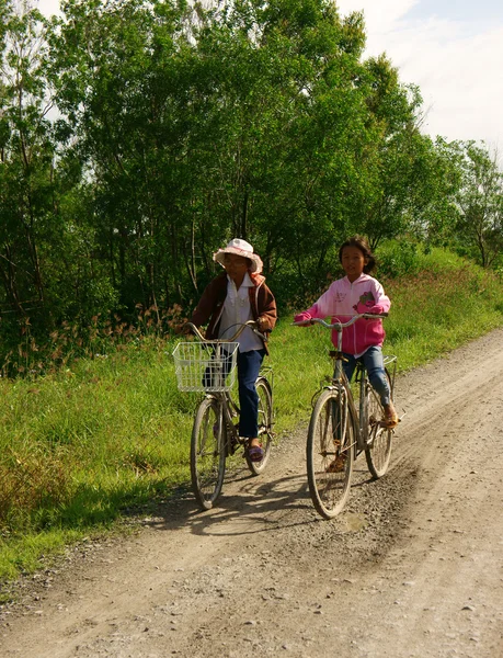 Children riding bike on country road — Stock Photo, Image