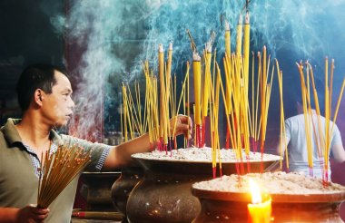 People burn incense at ancient pagoda clipart