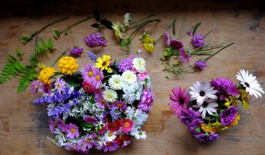 Evin içinde dekorasyon için güzel renkli çiçek aranjmanı, çeşitli küçük papatyalar bahar zamanı harika bir yer açmak için evden kesilmiş, ahşap üzerine süslemeye hazır vazolar.