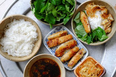 Aile yemeği için Vietnam yemekleri tepsisi, kızarmış bahar rulosu lahana, fesleğen yaprağı ve soya soslu pirinç eriştesi, et menüsü olmayanlar için sağlıklı vegan yemeği.