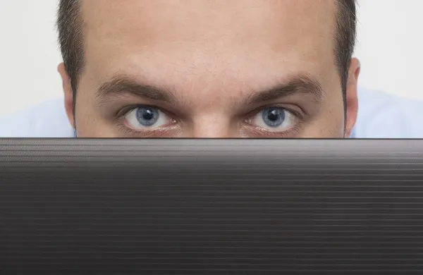 Hombre espiando sobre el ordenador portátil —  Fotos de Stock