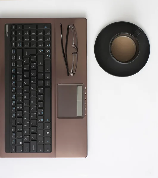 Laptop, glasögon och kaffe på skrivbordet — Stockfoto
