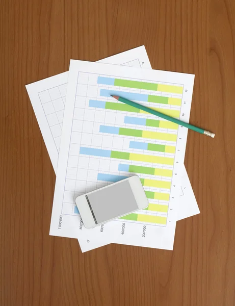 Smartphone, Bleistift und Diagramm auf dem Arbeitstisch — Stockfoto