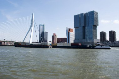 Nieuwe Maas nehri üzerinde Rotterdam 'ın merkezinde, Hollanda' da büyük bir kargo gemisiyle Erasmusbrug.