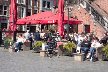 Nijmegen, Netherlands - April 16, 2022: People relax and enjoy a drink at an outdoor cafe terrace in the center of Nijmegen