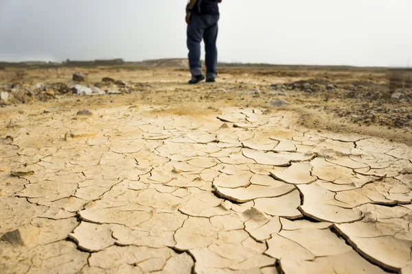 干燥的土壤的质地，模糊腿行走的人. — 图库照片
