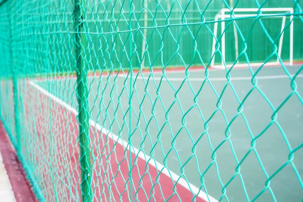Clôture de maillon de chaîne de couleur verte entourant la cour futsal . Images De Stock Libres De Droits