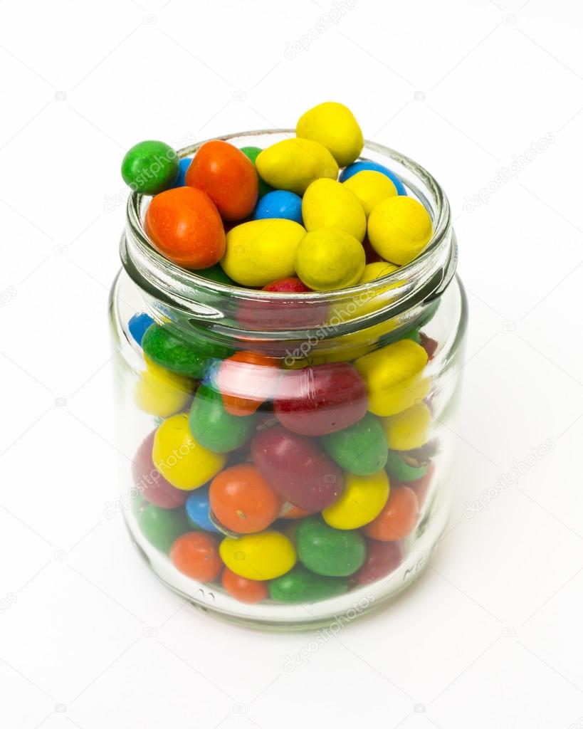 Isolated colorful candy in opened jar on white background.