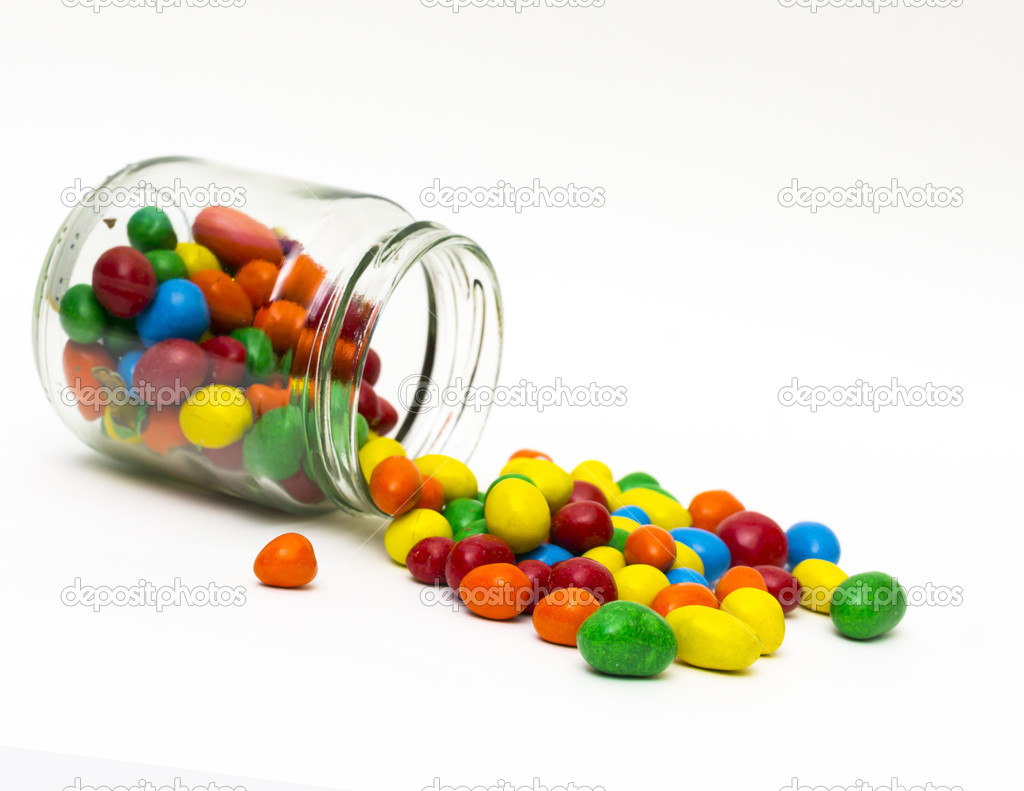 Isolated colorful candy out of jar on white background - selecti