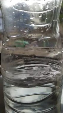  Su plastik şişeyi sallıyor.