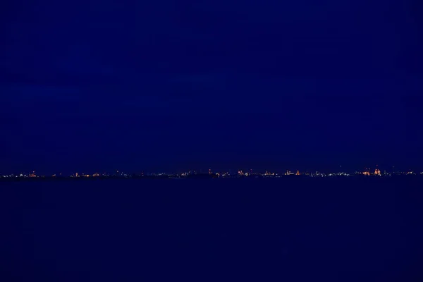 夜の海辺と雲と青空都市の夜 — ストック写真