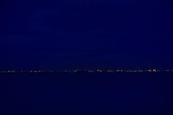 夜の海辺と雲と青空都市の夜 — ストック写真