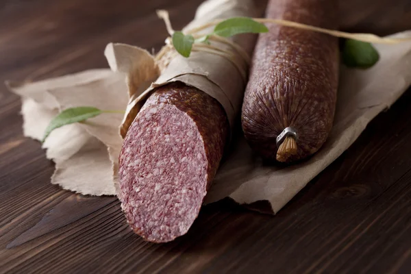 Salami on wooden and paper — Stock Photo, Image