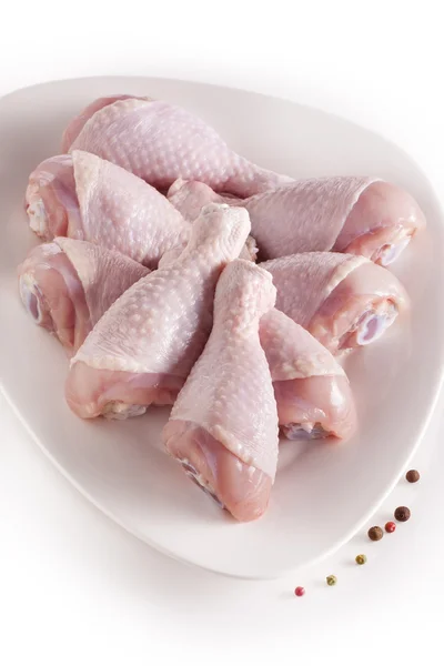 Gambe di pollo crude fresche su piatto bianco — Foto Stock